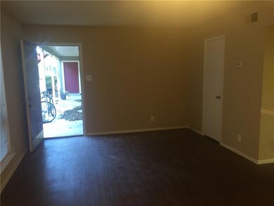 Unfurnished room featuring baseboards and dark wood-style flooring
