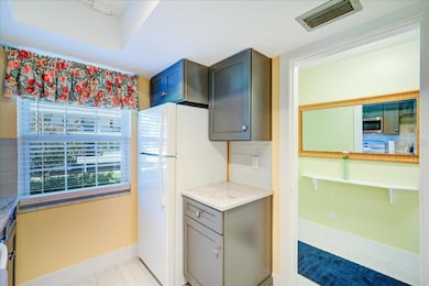 The updated kitchen boasts solid wood shaker-style cabinets, granite countertops, a large farmhouse sink, and a tasteful tile backsplash in clean, modern colors.