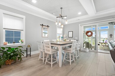 Dining space with a chandelier, light wood-style flooring, ornamental molding, a tray ceiling, and recessed lighting