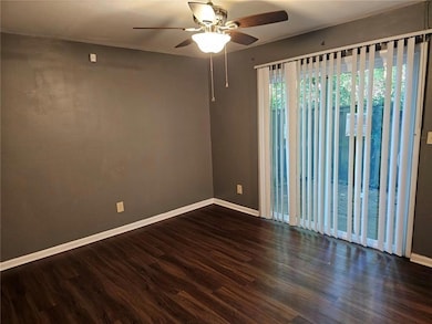 Unfurnished room with ceiling fan, baseboards, and wood finished floors