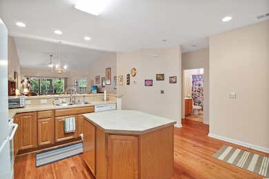 Kitchen featuring recessed lighting, light wood-style flooring, light countertops, a kitchen island, and open floor plan