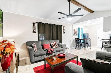 Living area with light tile patterned flooring, a textured ceiling, and a ceiling fan