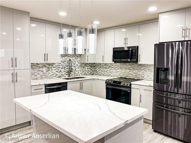 Kitchen with modern cabinets, white cabinetry, a s