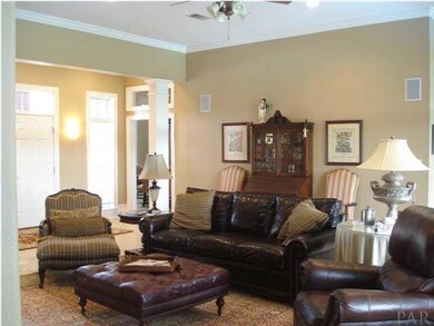 Living room with tile floors, high ceiling, crown molding.