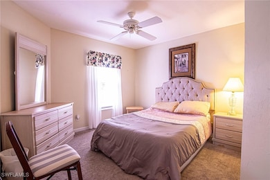 Carpeted bedroom featuring ceiling fan