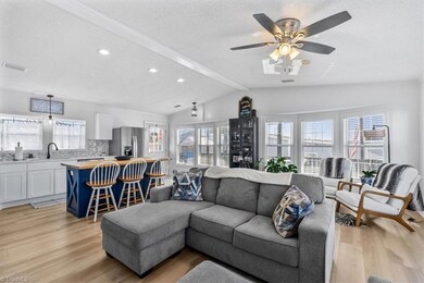 Alternate view of the living room features large windows on two sides.