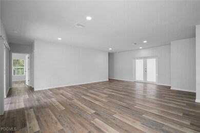 Spare room with light wood-style floors, recessed lighting, and french doors