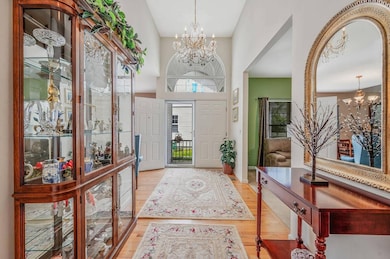 Entrance foyer featuring a chandelier, wood finished floors, and a towering ceiling