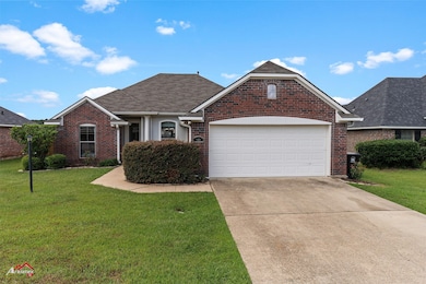 View of front of property featuring a front lawn, driveway, and roof with shingles