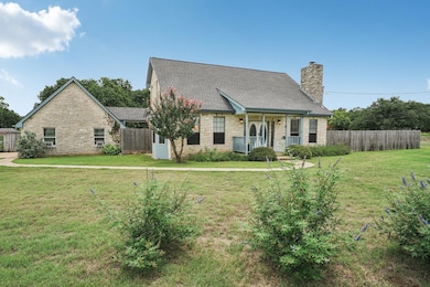 View of front facade with stone siding, a chimney
