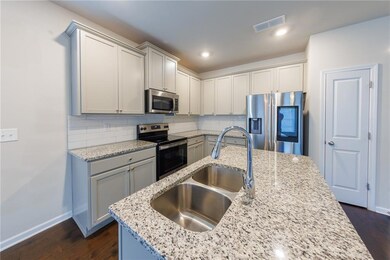 Kitchen featuring stainless steel appliances, tasteful backsplash, dark wood-type flooring, light stone counters, and recessed lighting