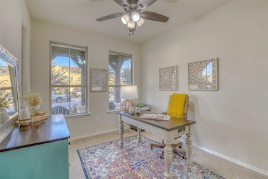 Carpeted office space featuring a ceiling fan and