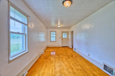 Unfurnished room with light wood-style flooring and baseboards