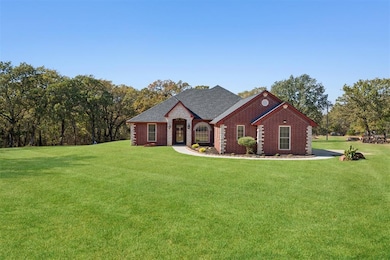 View of front of house with a front lawn, brick siding, and roof with shingles