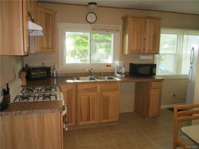 Kitchen has newer oak cabinets + ceramic tiled flo