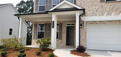 Property entrance with stone siding, a porch, and an attached garage