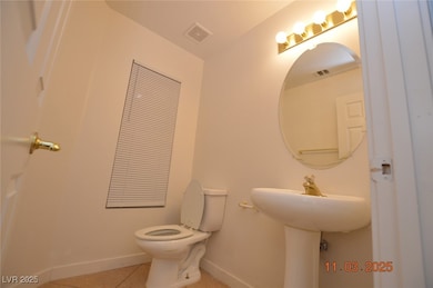 Half bathroom with light tile patterned floors and baseboards