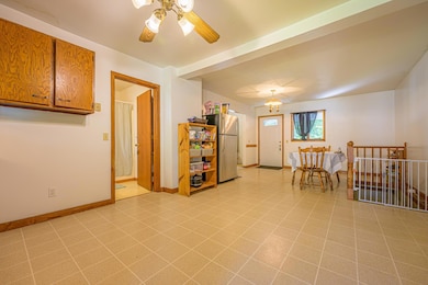 The kitchen features vinyl sheet flooring, wood cabinets, and a dining area.