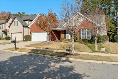 Traditional-style home featuring concrete driveway, brick siding, a garage, and a front lawn