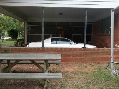 Large carport with circle driveway and lots of room for parking.
