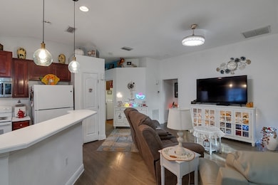 Living room featuring dark wood-type flooring, recessed lighting, and washer / dryer