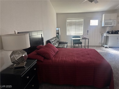 Bedroom featuring carpet, a textured wall, and a ceiling fan