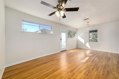 Empty room with healthy amount of natural light, light wood-style floors, and ceiling fan