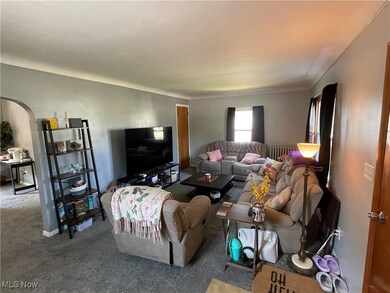 Carpeted living area with arched walkways