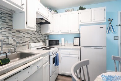 Kitchen featuring white cabinetry, sink, backsplas