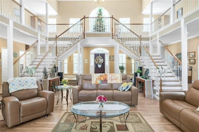 Living room with a towering ceiling, stairs, wood 