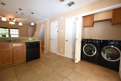 Kitchen with dishwasher, a sink, washer and clothes dryer, brown cabinets, and ceiling fan
