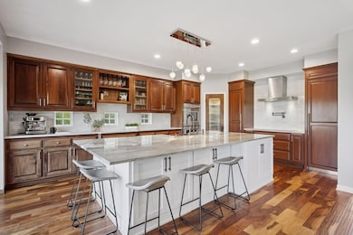Stunning kitchen where family & friends naturally gather.   Thermador appliances, separate fridge & freezer, induction cooktop, double oven, copper farmhouse sink and full quartzite slab center island from Brazil.