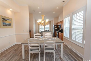 Dining room with crown molding, an inviting chande
