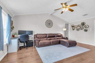 Living room featuring ceiling fan, crown molding, lofted ceiling with beam, and hardwood flooring
