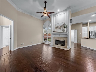 Unfurnished living room with ornamental molding, a fireplace, ceiling fan, dark wood-style flooring, and recessed lighting