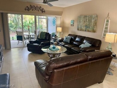 Living area with a ceiling fan and light tile patterned flooring