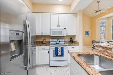 Kitchen featuring white appliances, ceiling fan, w