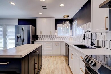 Kitchen featuring wooden counters, white cabinetry