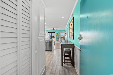 Corridor with light wood-type flooring and crown m