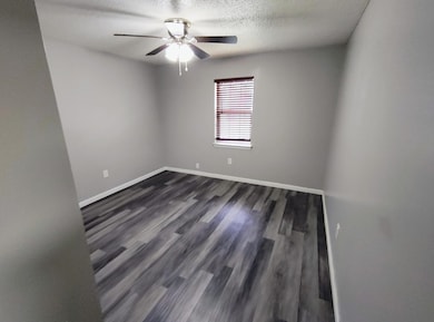 Empty room with dark wood finished floors, a textu
