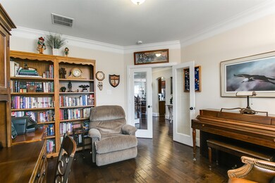 French door study has hardwood floors and double crown molding.