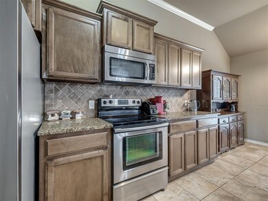 Kitchen with crown molding, vaulted ceiling, appli