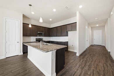 Kitchen featuring dark brown cabinetry, decorative light fixtures, tasteful backsplash, dark wood-style flooring, and recessed lighting