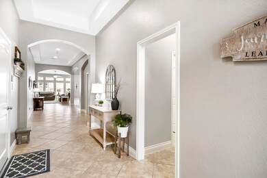 Beautiful grand entry with high ceilings, tile flooring, tray ceilings, and paint color with soft neutral tones and white trim! Same tile through out the home.