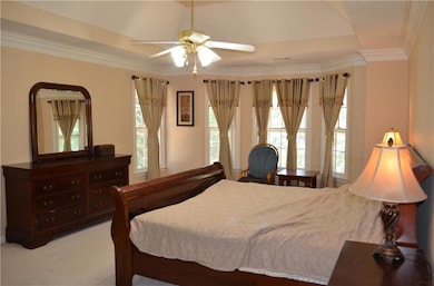 Carpeted bedroom featuring a ceiling fan and ornam