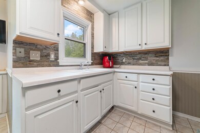 Kitchen featuring white cabinetry, sink, tasteful 