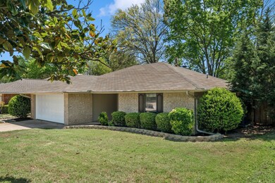 Ranch-style house featuring a garage, a front lawn