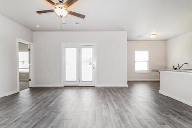 Unfurnished living room with sink, ceiling fan, an
