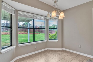 Unfurnished dining area featuring a wealth of natural light, tile patterned flooring, baseboards, and an inviting chandelier