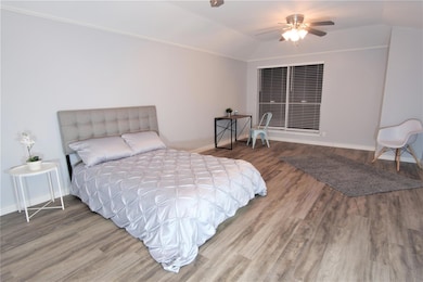 Bedroom featuring wood finished floors, baseboard